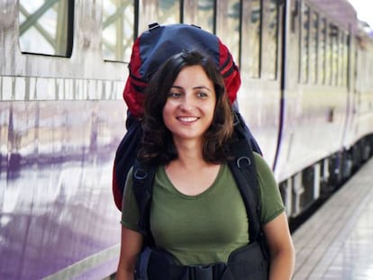 Una joven mochilera camina en una estación de tren.