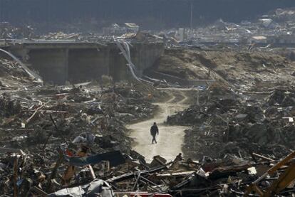 Un superviviente camina entre los escombros en la ciudad de Rikuzentakata.