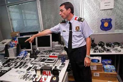 Un agente muestra el material intervenido a la banda internacional que falsificaba tarjetas.