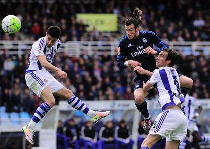 Gareth Bale (C) del Real Madrid golpea de cabeza el balón ante la mirada de Yuri Berchiche (i) y Mikel González.