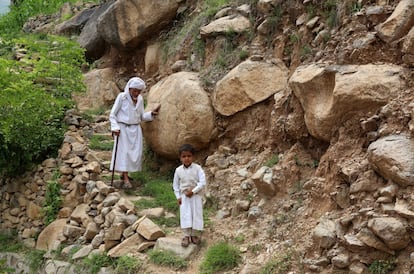 Un hombre y un niño pasean a lo largo de un camino de la montaña Dhalamlam.
