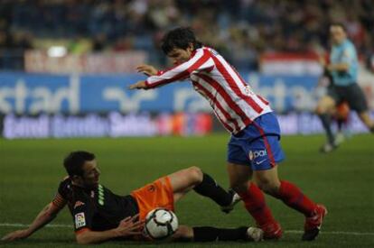 Marchena, ante Agüero, toca el balón con una mano en el área. Un penalti que Pérez Burrull (al fondo) no pitó de entrada, lo que provocó la protesta masiva del Atlético.
