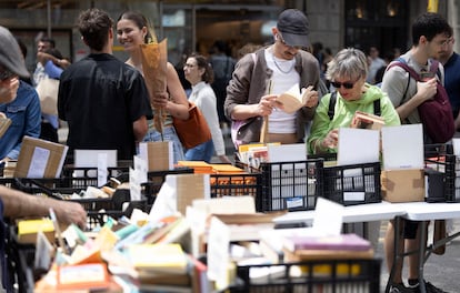 Varias personas revisan diferentes libros en uno de los puestos, este miércoles en Barcelona.