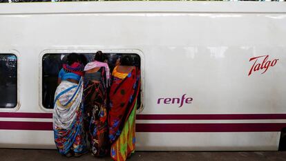 Varias personas observan un tren Talgo a su llegada a Bombay.