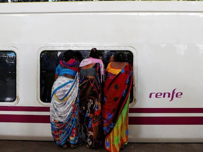 Varias personas observan un tren Talgo a su llegada a Bombay. 