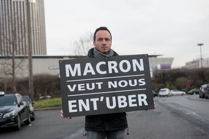 Un taxista de París sujeta una pancarta contra las decisiones de Macron a favor de Uber, en enero de 2016