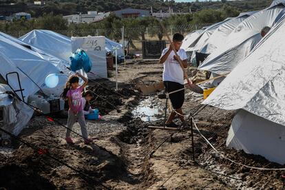 Una niña sostiene un globo aerostático mientras camina entre tiendas de campaña en el campamento Kara Tepe en la isla de Lesbos (Grecia), el pasado 14 de octubre.