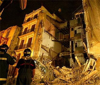 Los bomberos, anoche, ante los restos del edificio que se desplomó en el centro de Valencia.