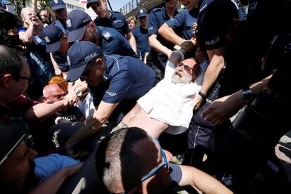 Policias forcejean con manifestantes durante una protesta cerca de la sede del partido Ley y Justicia, en Varsovia, Polonia.