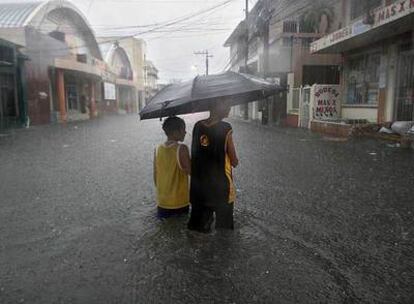Dos jóvenes vadean una calle inundada en la ciudad portuaria de La Ceiba (Honduras).