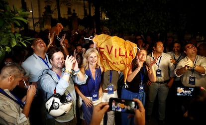 Un grupo de seguidores del PP celebran los resultados de las elecciones de este domingo frente a la sede de la formación en Sevilla.