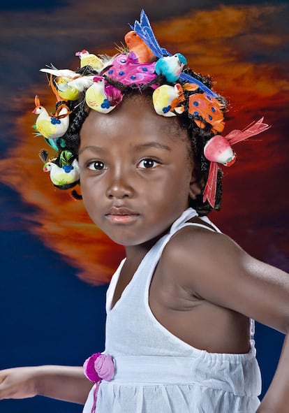 <p>Esta imagen fue ganadora de un accésit en la edición de 2013 del concurso Africanas en España y forma parte de una colección compuesta por 11 fotografías titulada ‘Mujeres con cosas en la cabeza’. Su autora, Esperanza Fernández Campayo, llevó a cabo este proyecto con la idea de reflejar los pensamientos e ideas que pueblan las mentes de las mujeres de todas las culturas. ‘Fantasía’, como se titula la instantánea, representa a la pequeña Kiara, que es miembro de una familia originaria de Guinea Ecuatorial. “Trato de reflejar lo que tiene en mente una niña de cuatro años que cambia de continente persiguiendo el sueño europeo de sus mayores. Pajaritos en la cabeza", resume la fotógrafa.</p> <p>En la actualidad, Kiara tiene 11 años y, aunque nació en España, reside en Guinea Ecuatorial con su madre, Reina Oyo Sam, y su hermana mayor Keila. "Reina es madre soltera, tiene dos hijas excepcionales. Vino a España con un sueño, pensando que aquí lo realizaría mejor y más deprisa. El tiempo pasaba, pero el sueño no se acercaba. Cansada de vivir de ayudas sociales, un día decidió que, lejos de ser una derrota, el regreso a su país era la clave", cuenta la fotógrafa, que conoció a esta familia a través de la Asociación Espiral Loranca, en la que trabaja. Hoy, Reina es presentadora de televisión y una gran activista por los derechos de las mujeres.</p> <p>Fernández Campayo nació en Fuenlabrada (Madrid). Estudió fotografía en varias escuelas de la capital y ha participado en diversos concursos y exposiciones tanto individuales como colectivas, en distintos centros culturales de su Comunidad. </p>