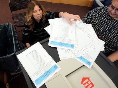 Trabajadoras electorales prueban la máquina de recuento de papeletas para las primarias de Nuevo Hampshire en el Centro Municipal de Derry.