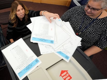 Trabajadoras electorales prueban la máquina de recuento de papeletas para las primarias de Nuevo Hampshire en el Centro Municipal de Derry.