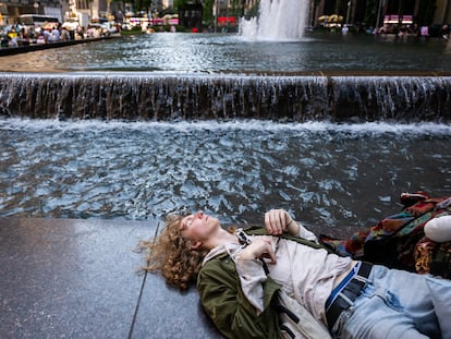 Un joven descansa junto a una fuente en el centro de Manhattan durante una ola de calor, en junio de 2024 en Nueva York.