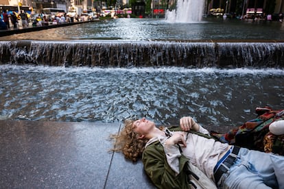 Un joven descansa junto a una fuente en el centro de Manhattan durante una ola de calor, en junio de 2024 en Nueva York.