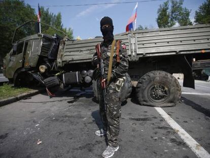 Um membro de um grupo armado pró-russo vigia uma barricada próxima a Donetsk.