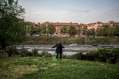 Un hombre mira la M-40 desde una zona de jardines en Ciudad de los Ángeles, en el distrito de Villaverde de Madrid. 