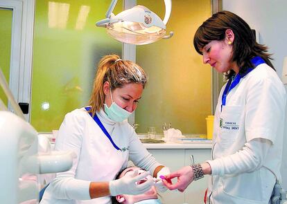 Dos dentistas atienden a una paciente en un hospital.