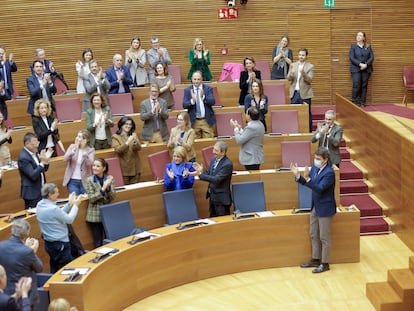 El presidente de la Generalitat, Carlos Mazón (d) aplaude a su grupo parlamentario tras la aprobación de los primeros presupuestos del Gobierno PP-Vox.