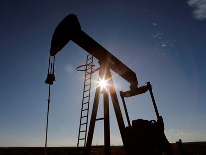 FILE PHOTO: The sun is seen behind a crude oil pump jack in the Permian Basin in Loving County, Texas, U.S., November 22, 2019. REUTERS/Angus Mordant/File Photo