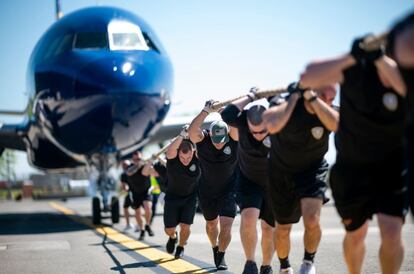 Un grupo de competidores tira de un avión JetBlue A320 mientras participan en un "Plane Pull" en el Aeropuerto Internacional John F. Kennedy en Nueva York (EE UU), el 21 de mayo de 2019. Oficiales de policía de las comunidades de Nueva York y el Reino Unido compitieron para crear conciencia sobre la Fundación "Joining Against Cancer in Kids" (JACK).