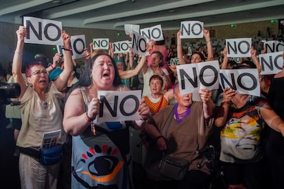 El público y supervivientes del Patronato de Protección a la Mujer sujetan carteles de protesta durante el acto  en la Fundación Pablo VI en Madrid.