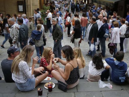 Turistas tomando pintxos en las escaleras de la Iglesia Santa Mar&iacute;a de la Parte Vieja de San Sebasti&aacute;n.