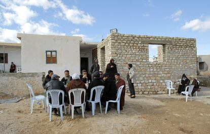 Los hombres se reúnen en el exterior de la humilde casa familiar en Sbitla y reciben el pésame de los vecinos.