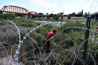 Un hombre camina a lo largo de una alambrada en el Río Grande, en Texas, Estados Unidos. 