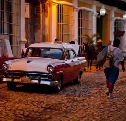 Existe otra Cuba más allá del “todo incluido” de Varadero. Una forma de descubrirla es alojándose en casas particulares. Son más baratas que los hoteles, permiten conocer el día a día de la isla y son una inestimable fuente de ingresos para quienes alquilan las habitaciones. El Gobierno cubano acaba de aprobar una resolución que permite a las agencias estatales incluir en su oferta los más de 5.000 habitaciones y 1.700 paladares (restaurantes particulares) que existen en el país. En la fotografía, un antiguo taxi, o almendrón, en Trinidad. Más información en www.casapar­ticularcuba.org