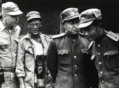 Robert Tuckman, corresponsal de guerra de Associated Press, a la izquierda, junto con unos oficiales de Corea del Norte en un descanso entre batallas.