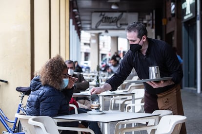 Un camarero sirve un café a una clienta en la Cafetería Tristana, durante el primer día de apertura de bares y restaurantes en Badajoz el 12 de febrero.