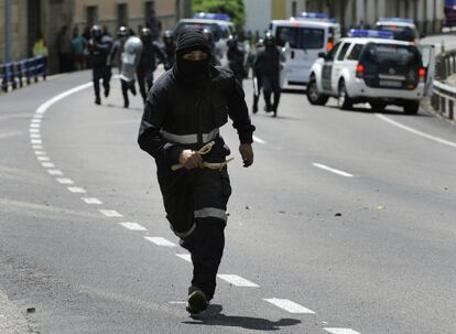 Un minero corre delante de los guardias civiles en Ciñera, durante los cortes de carretera.