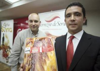 El vicepresidente de la Asociación de Fabricantes de Torreznos de Soria, Teo Martínez (dcha.), muestra la primera etiqueta en compañía del director técnico, Juanjo Delgado Soto.