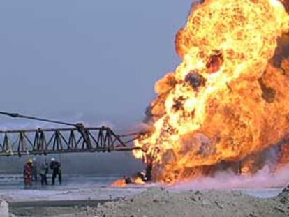 Un grupo de bomberos intenta apagar un incendio en un pozo petrolero iraquí.