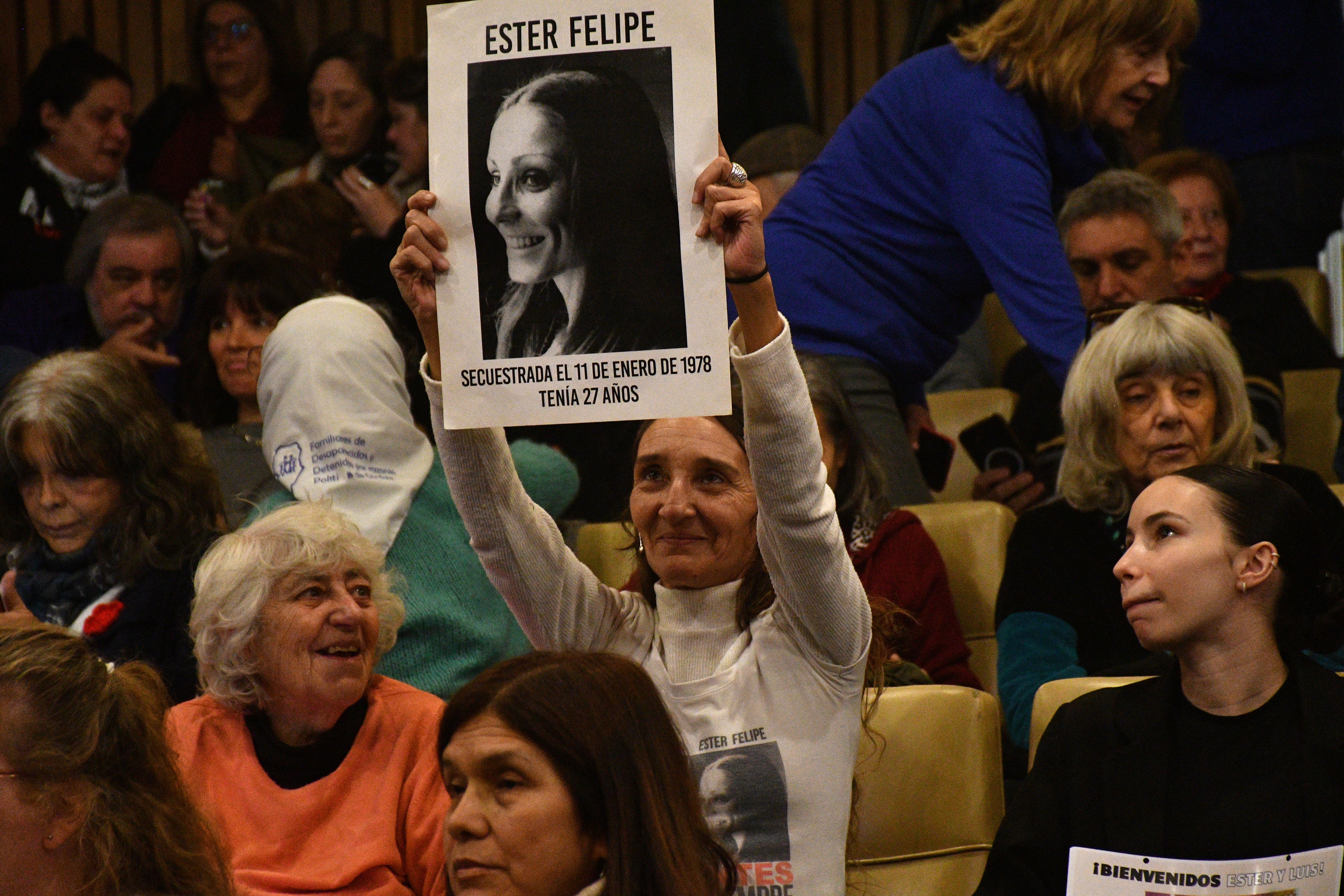 Una mujer muestra una foto de Ester Felipe, desaparecida en Argentina.