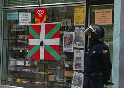 Un policía custodia la tienda donde ocurrió el tiroteo ayer en Pamplona.