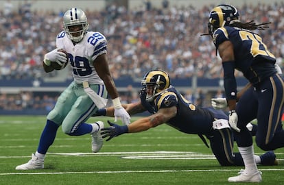 DeMarco Murray, de Dallas Cowboys, corre delante de Chris Long, de St. Louis Rams, durante un partido de la NFL.