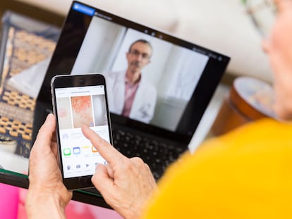 Una mujer consulta su móvil durante una consulta de telemedicina.