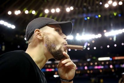 Curry, jugador de los Warriors, fuma un puro tras derrotar a los Cavaliers de Cleveland y ganar el campeonato.