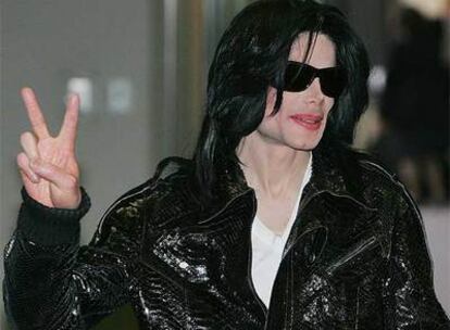 Michael Jackson hace el signo de la victoria a su llegada el domingo a Tokio.