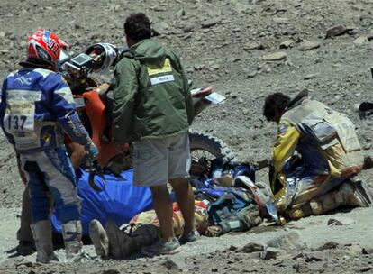 Un médico de la organización del Rally Dakar y dos participantes atienden a Guerrero, tendido en el suelo tras sufrir la caída.
