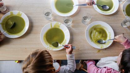 Varios niños comen crema de guisantes en la escuela infantil municipal La Melonera de Madrid, que recibe comida ecológica de proximidad.
