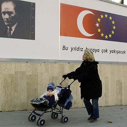 Una mujer pasea en Ankara ante un cartel de Ataturk y otro sobre la relación de Turquía con la UE.