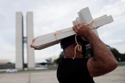 Un manifestante sostiene cruces de madera en una protesta frente al Congreso de Brasil contra la gestión de la pandemia del Gobierno, el 19 de marzo.