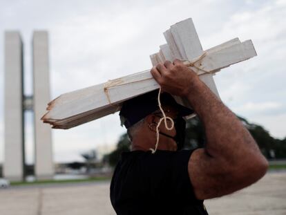 Un manifestante sostiene cruces de madera en una protesta frente al Congreso de Brasil contra la gestión de la pandemia del Gobierno, el 19 de marzo.