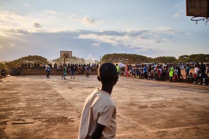 Un niño mira el partido de baloncesto que se celebra cada tarde en la cancha del campo de refugiados de Dzaleka.