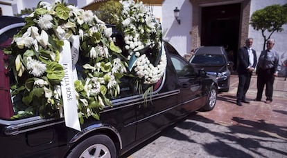 Coche fúnebre con las coronas de flores para despedir al diseñador David Delfín, en la que se puede ver la corona de flores de la familia Bo´se.