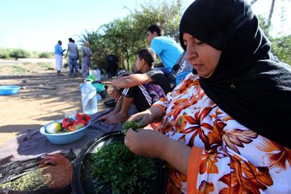 Tufaha, una mujer siria que forma parte del campamento, pica perejil para condimentar la comida.